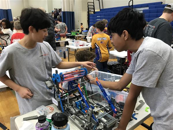 Students work on their robot at a VEX IQ Robotics competition.